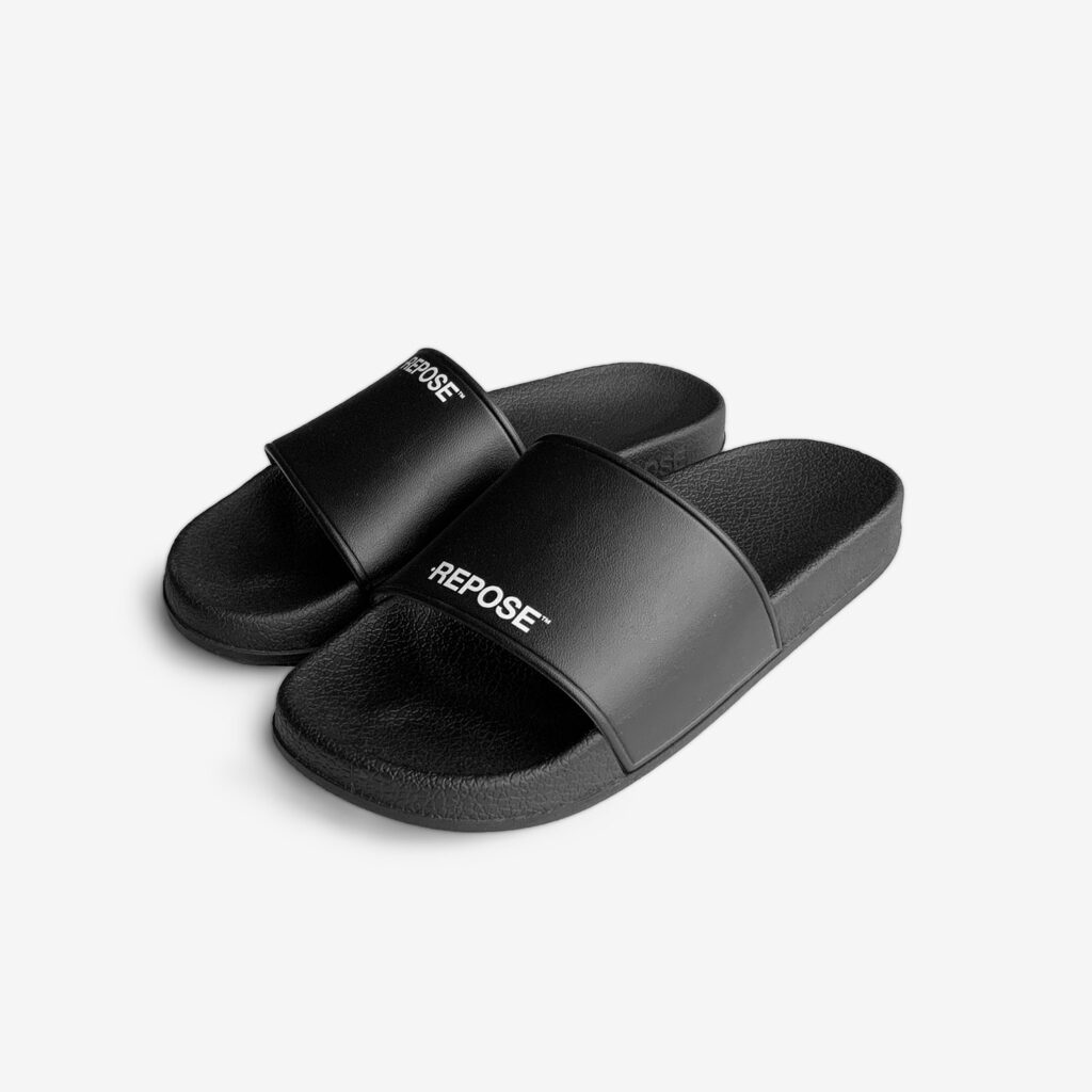 Repose Logo Sandal Black in Rubber and uneven logo.